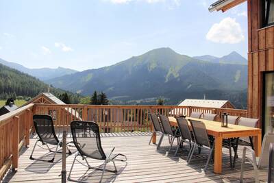 Veranda met uitzicht over de bergen, van een vakantiehuis op Alps Resorts Almdorf Hohentauern