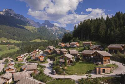 Luchtfoto van chalets op Alps Resorts Alpendorf Dachstein West, met daarachter bergen