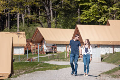 Stel wandelt tussen de glamping tenten op Alps Resorts Chalets en Glamping Nassfeld