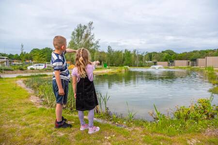 2 Kinderen naast een vijver met een fontein op vakantiepark EuroParcs Maasduinen