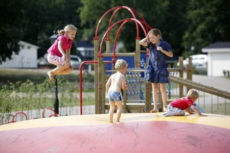 Kinderen springen op de airtrampoline in een speeltuin op vakantiepark Familiehuis Nunspeet