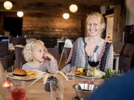 Een gezin dineert in het restaurant op vakantiepark Landal Beach Park Ebeltoft