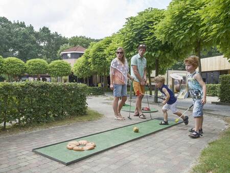 Een gezin speelt een potje midgetgolf op vakantiepark Landal De Vers