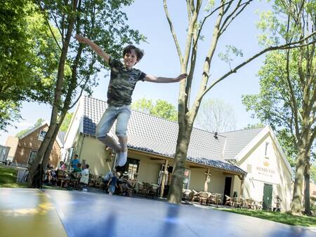 Kind springt op de airtrampoline in de speeltuin van vakantiepark Landal de Waufsberg