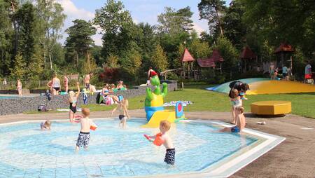 Kinderen spelen in het peuterbad buiten op vakantiepark Molecaten Park Landgoed Ginkelduin