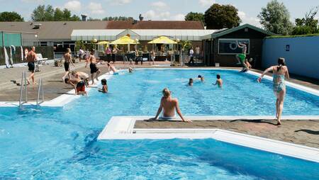 Mensen zwemmen in het buitenbad van vakantiepark Molecaten Park Rondeweibos