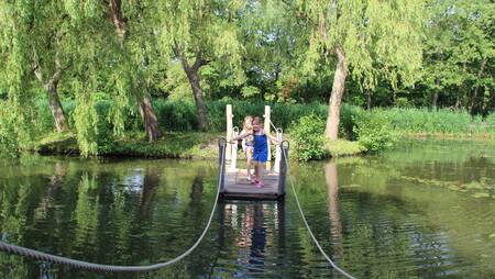 Kinderen varen op een vlot op vakantiepark Molecaten Waterbos