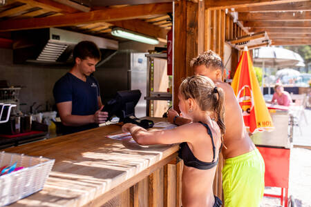 Jongen en meisje voor de snackbar van vakantiepark RCN les Collines de Castellane
