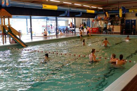 Mensen zwemmen in het binnenbad van vakantiepark Roompot Bospark 't Wolfsven