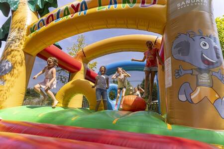 Kinderen springen op het springkussen op vakantiepark Roompot Côte de Nacre
