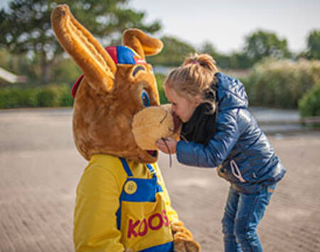 Meisje knuffelt met Koos konijn op vakantiepark Roompot Vakantiepark Boomhiemke