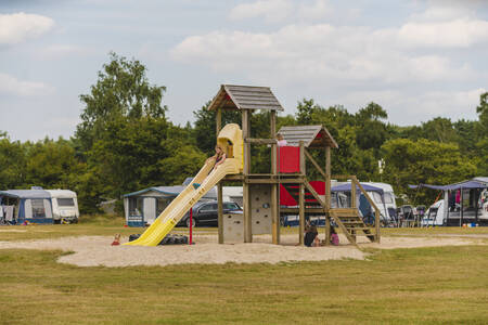 Kinderen spelen in een speeltuin op het een kampeerveld op vakantiepark Wilsumer Berge